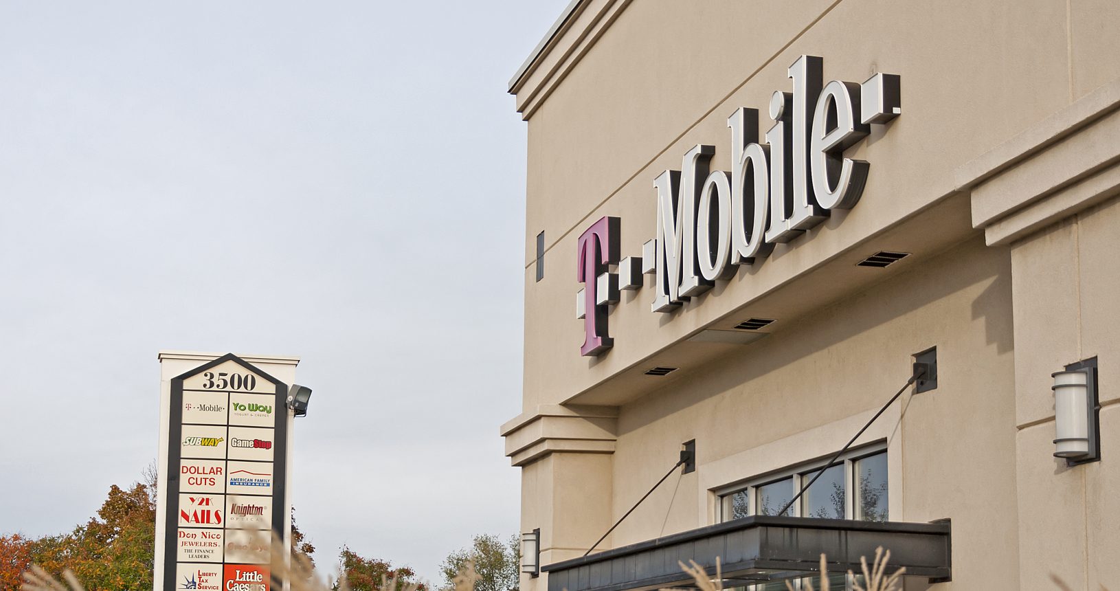 A t-mobile store with tall grass in front of it.