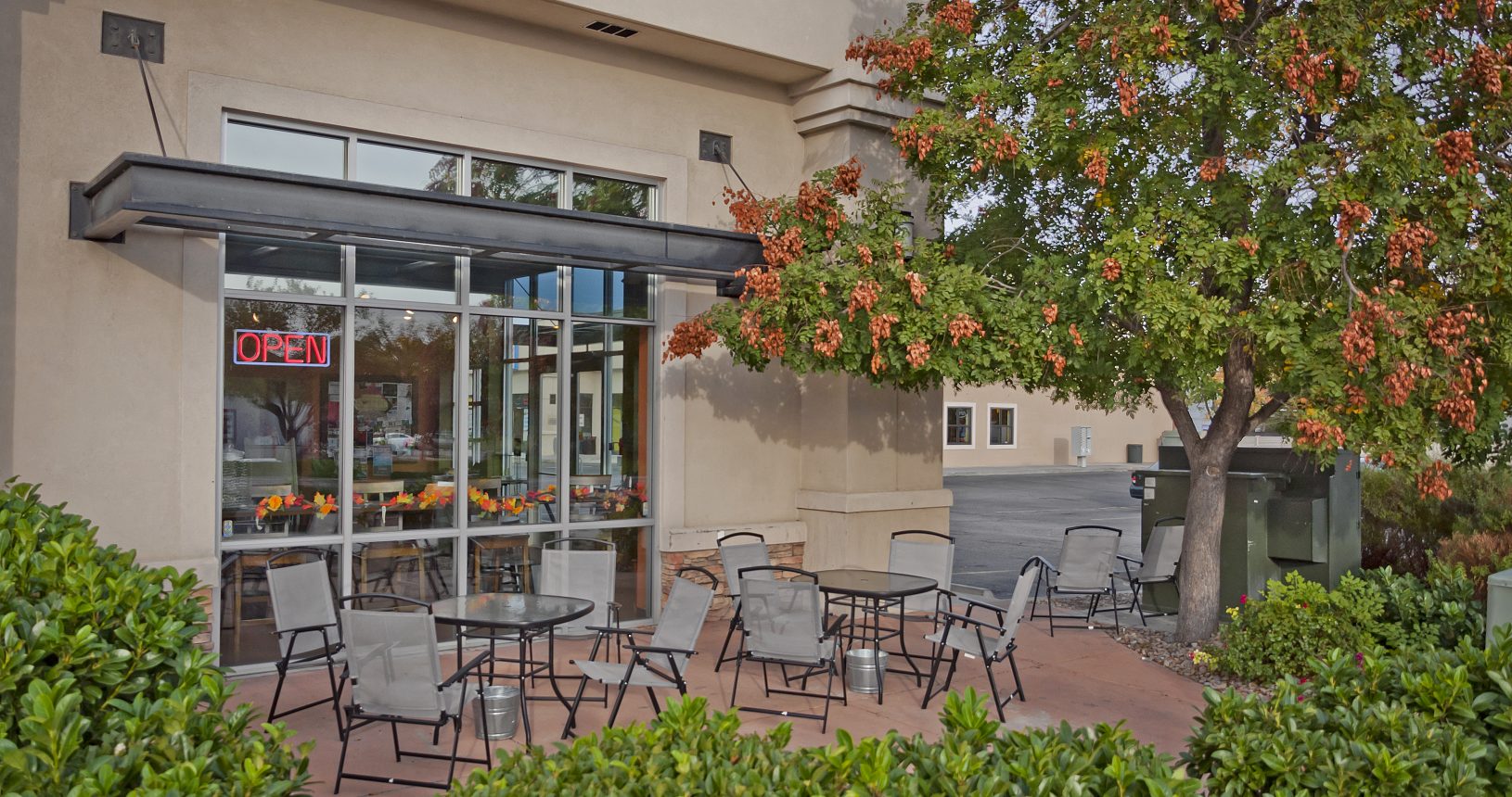 A patio with tables and chairs outside of a building.