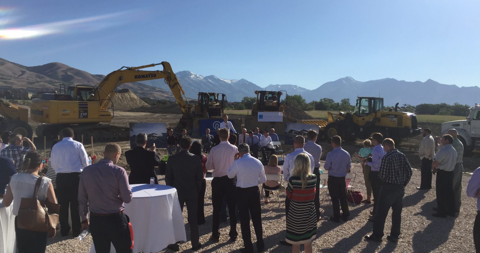 A group of people standing around in front of some construction equipment.