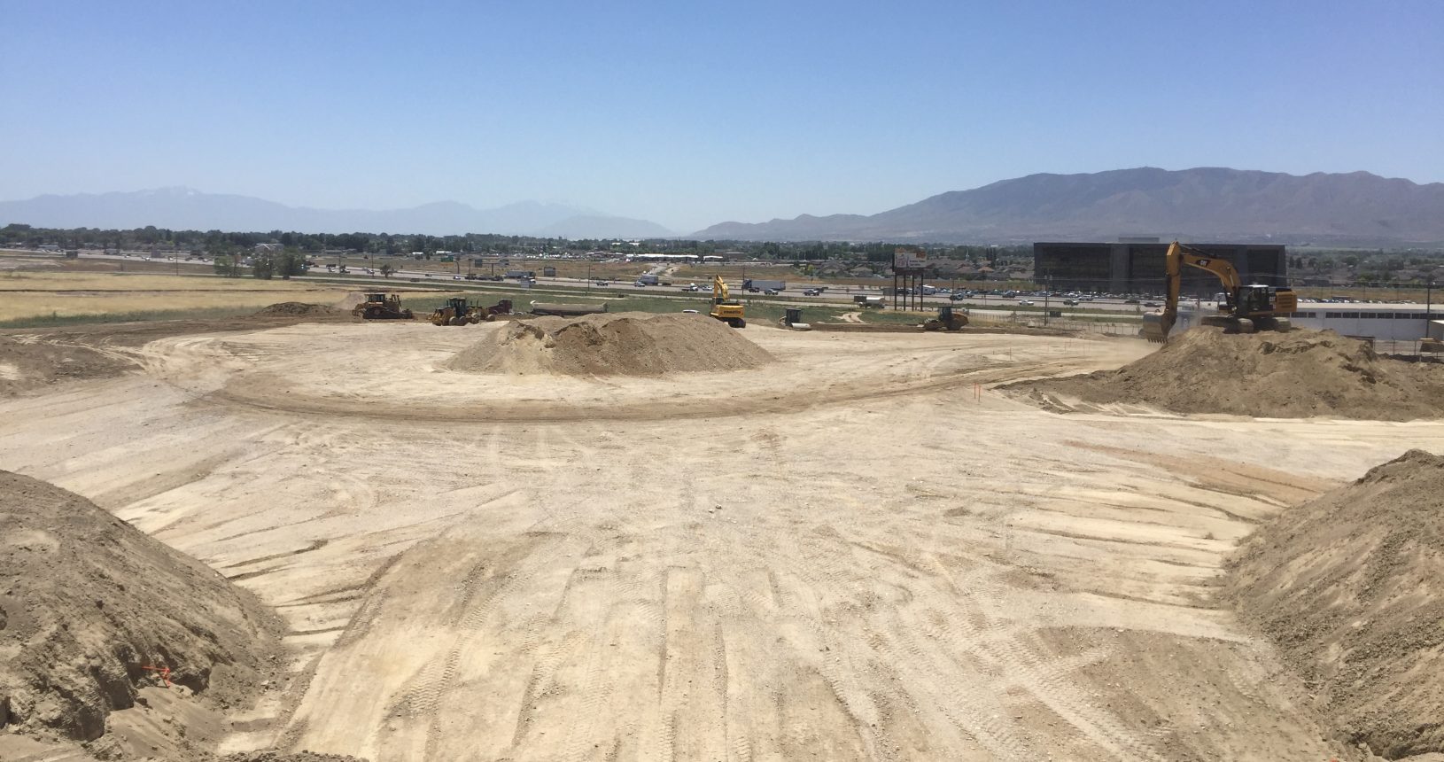 A dirt bike track with lots of sand and hills in the background.