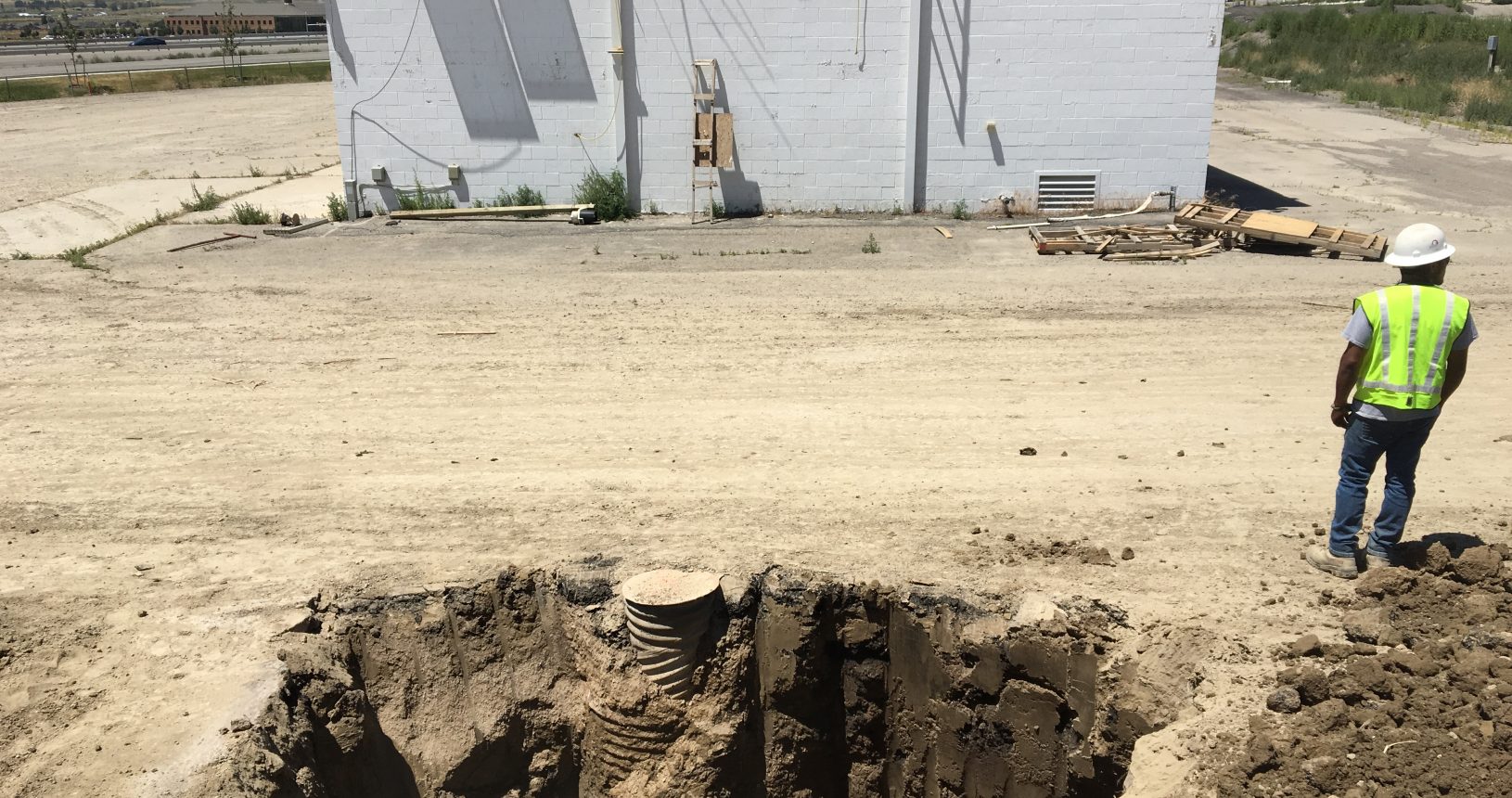 A white building sitting in the middle of an empty dirt field.