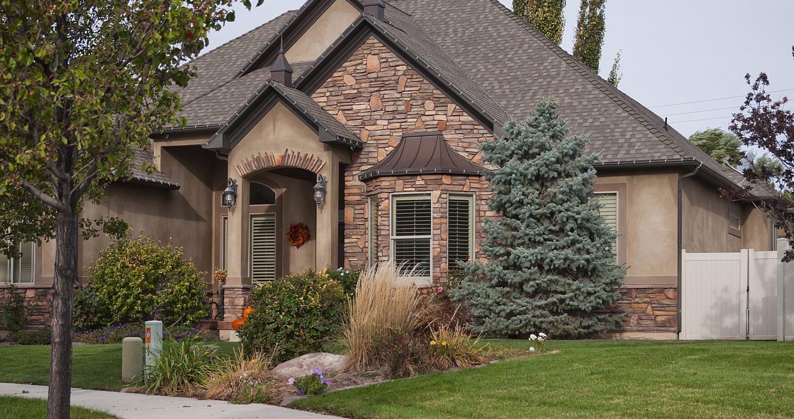 A house with a driveway and trees in front of it