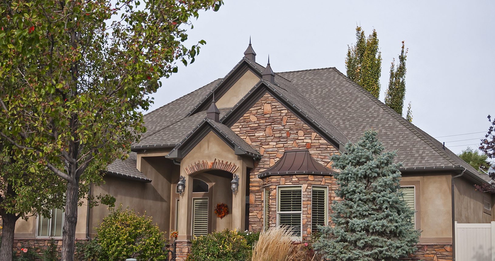 A house with a driveway and trees in the background.