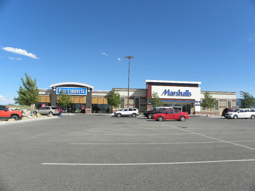 A parking lot with cars parked in front of the store.