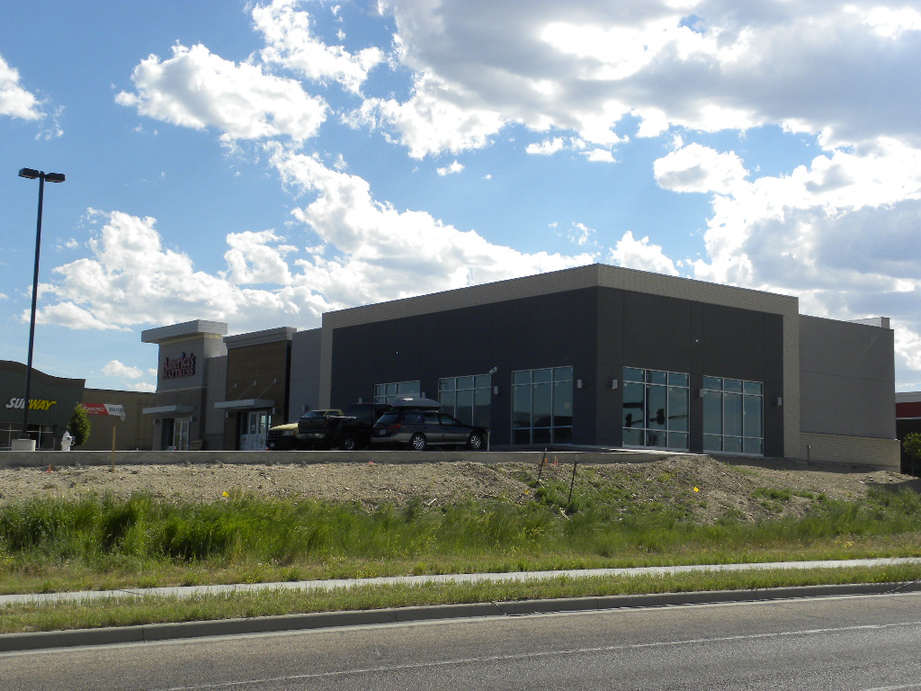 A large building with a car parked on the side of it.