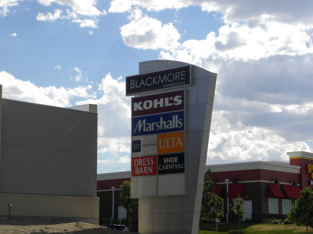 A sign for stores in front of a building.