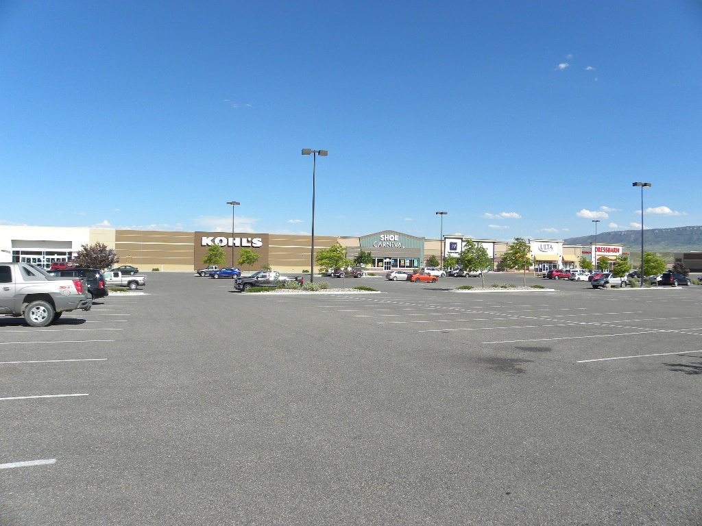 A large empty parking lot with cars parked in it.