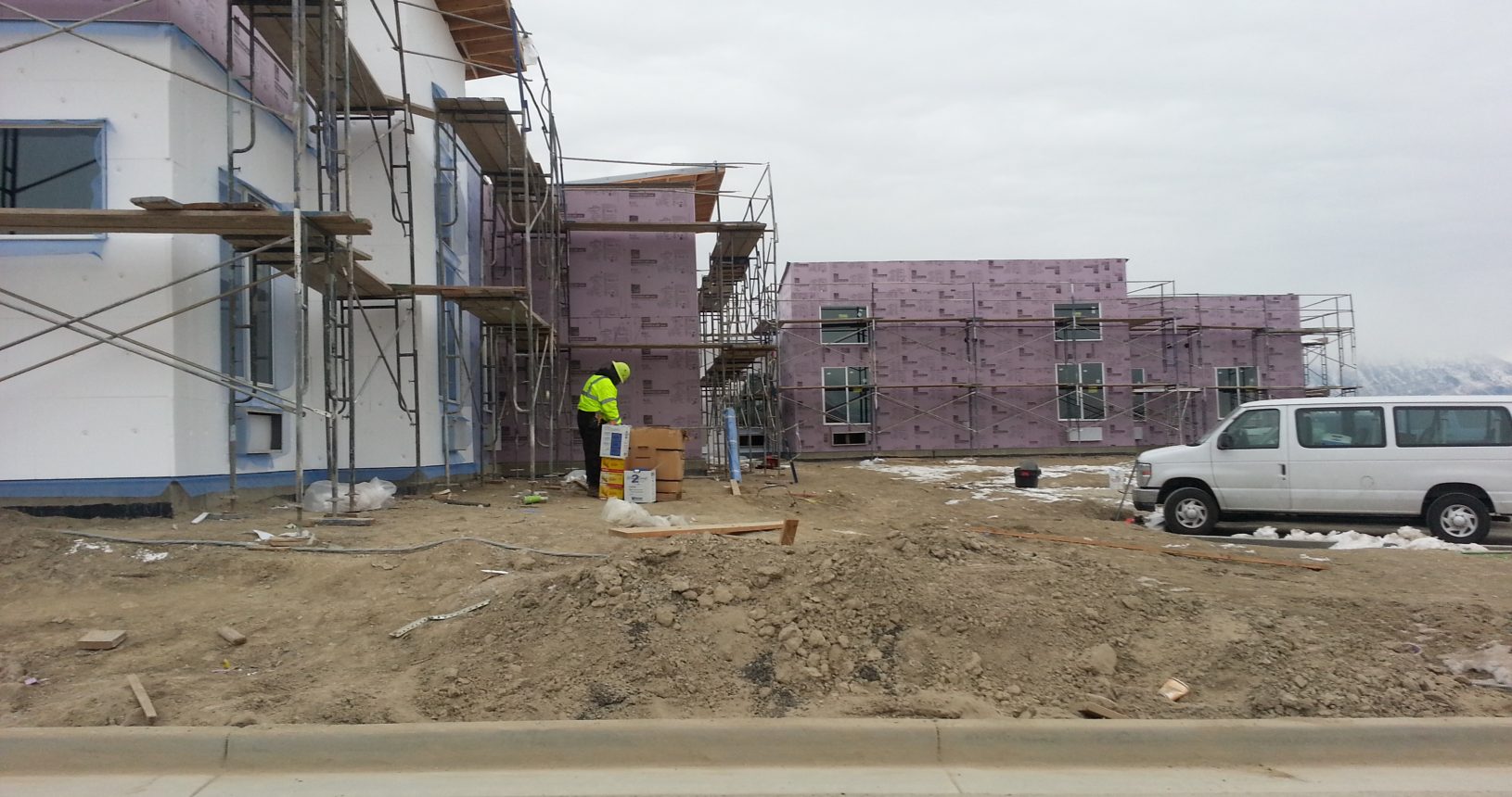 A construction worker standing on top of dirt.