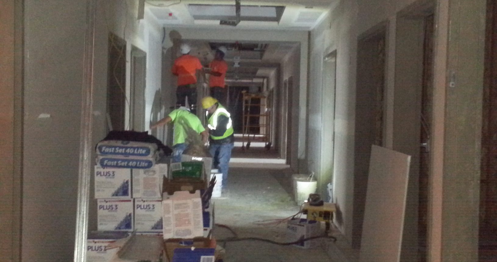 A hallway with workers in the center of it.