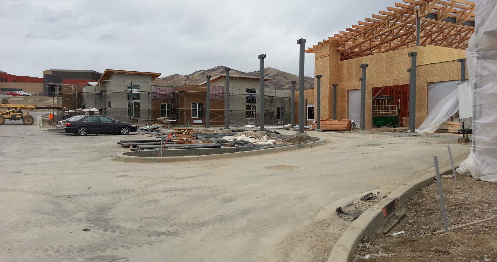 A building under construction with a car parked in front of it.