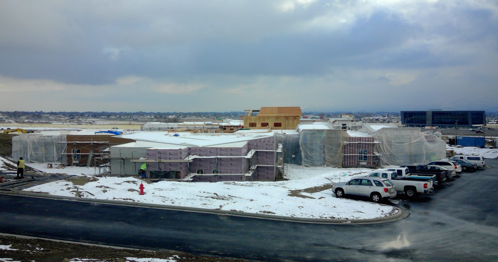 A view of a snowy field with buildings in the background.