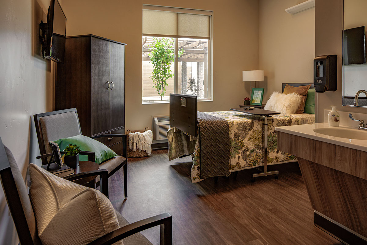 A bedroom with two beds and a desk in it