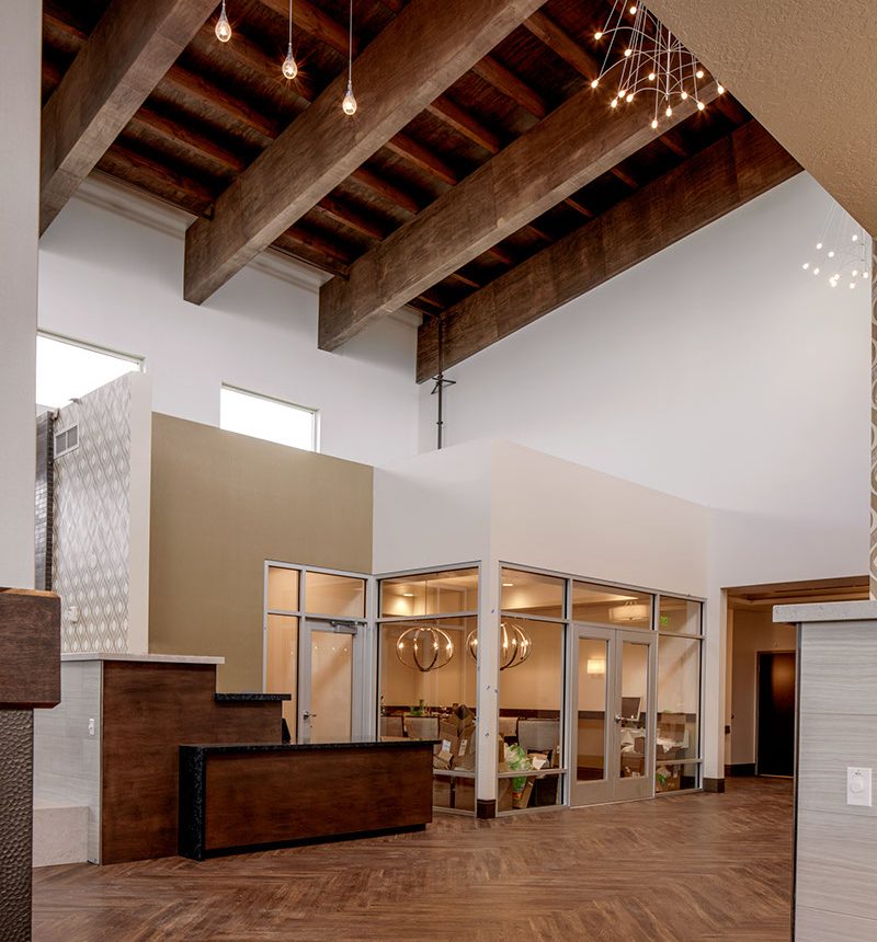 A lobby with wooden floors and a large open ceiling.