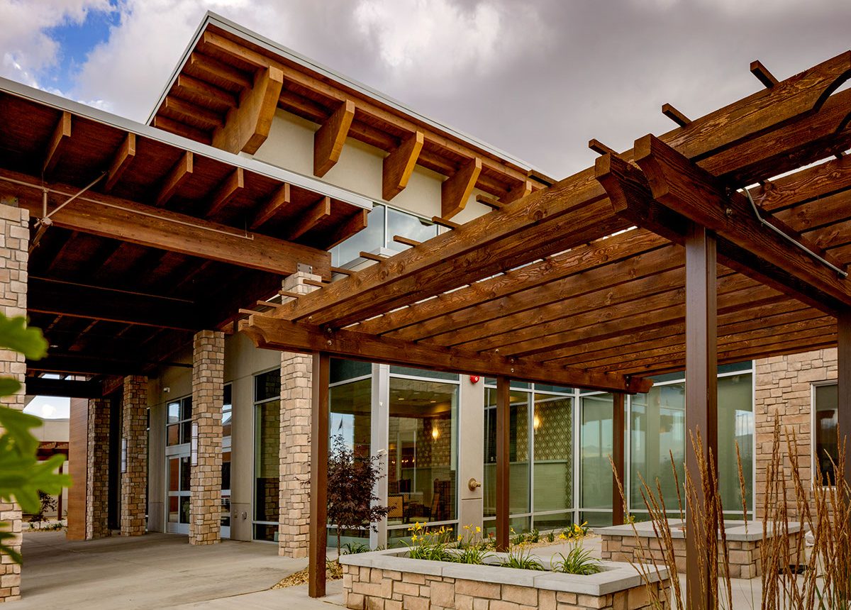 A building with a large wooden pergola over the entrance.