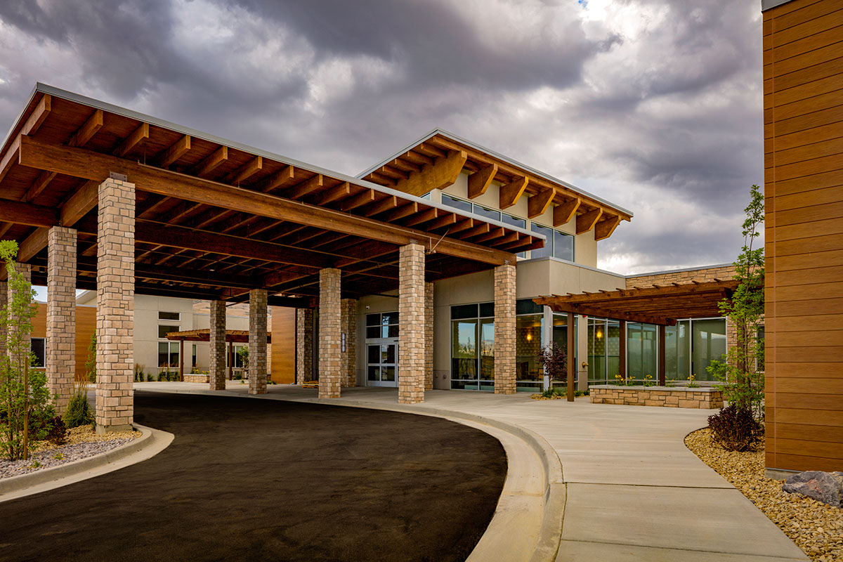 A building with a large entrance and a cloudy sky.