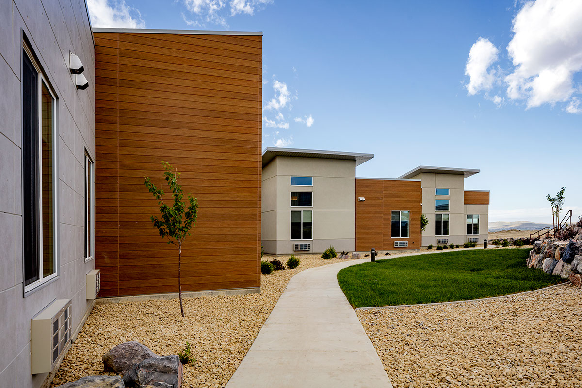 A walkway leading to two buildings on the side of a hill.