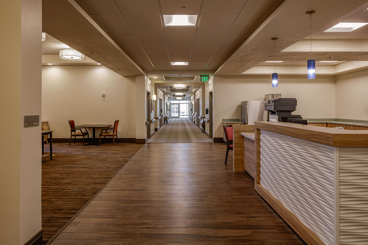 A long hallway with tables and chairs in it.