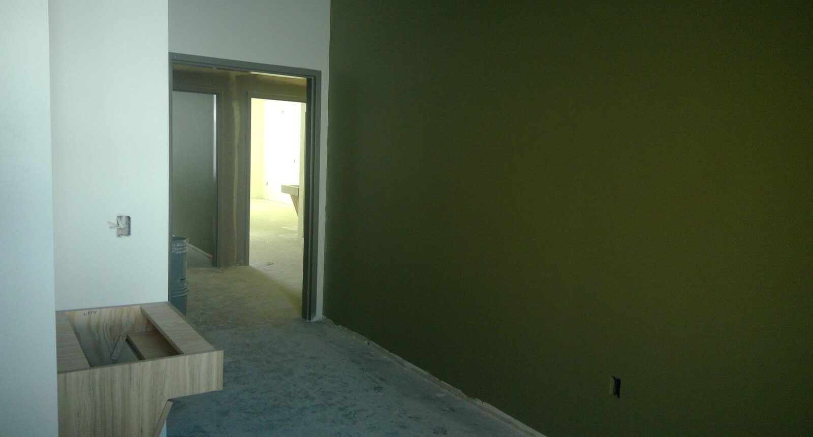 A room with green walls and white tile floor.