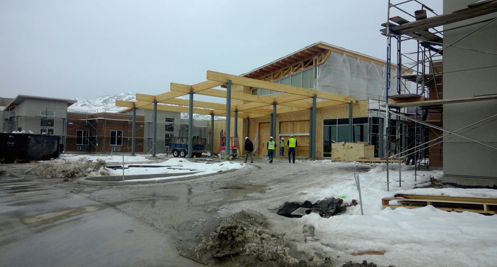 A building under construction with people standing around.