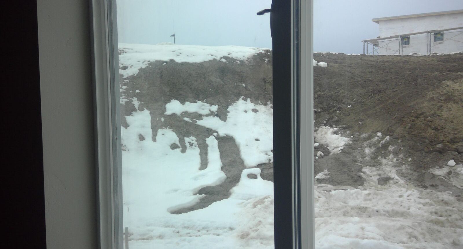 A view of snow from the window of a room.