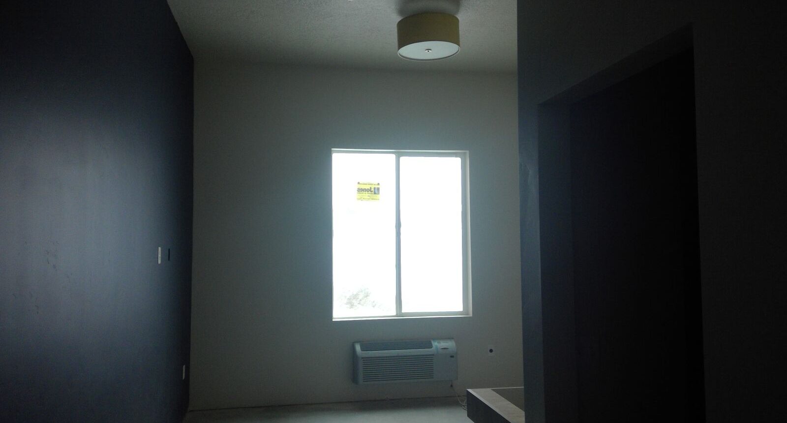 A room with a window and a light in it