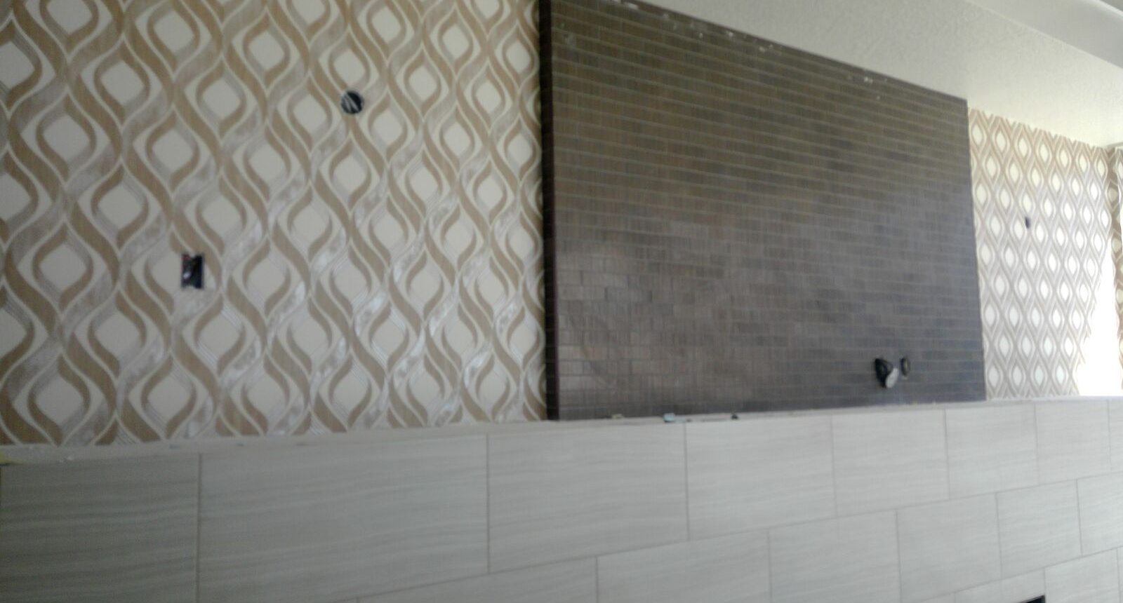 A wall with some white tiles and a brown tile