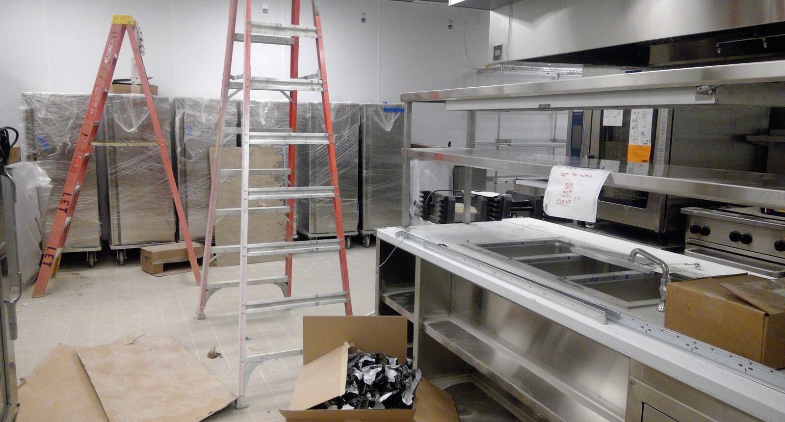 A kitchen with a ladder and some boxes