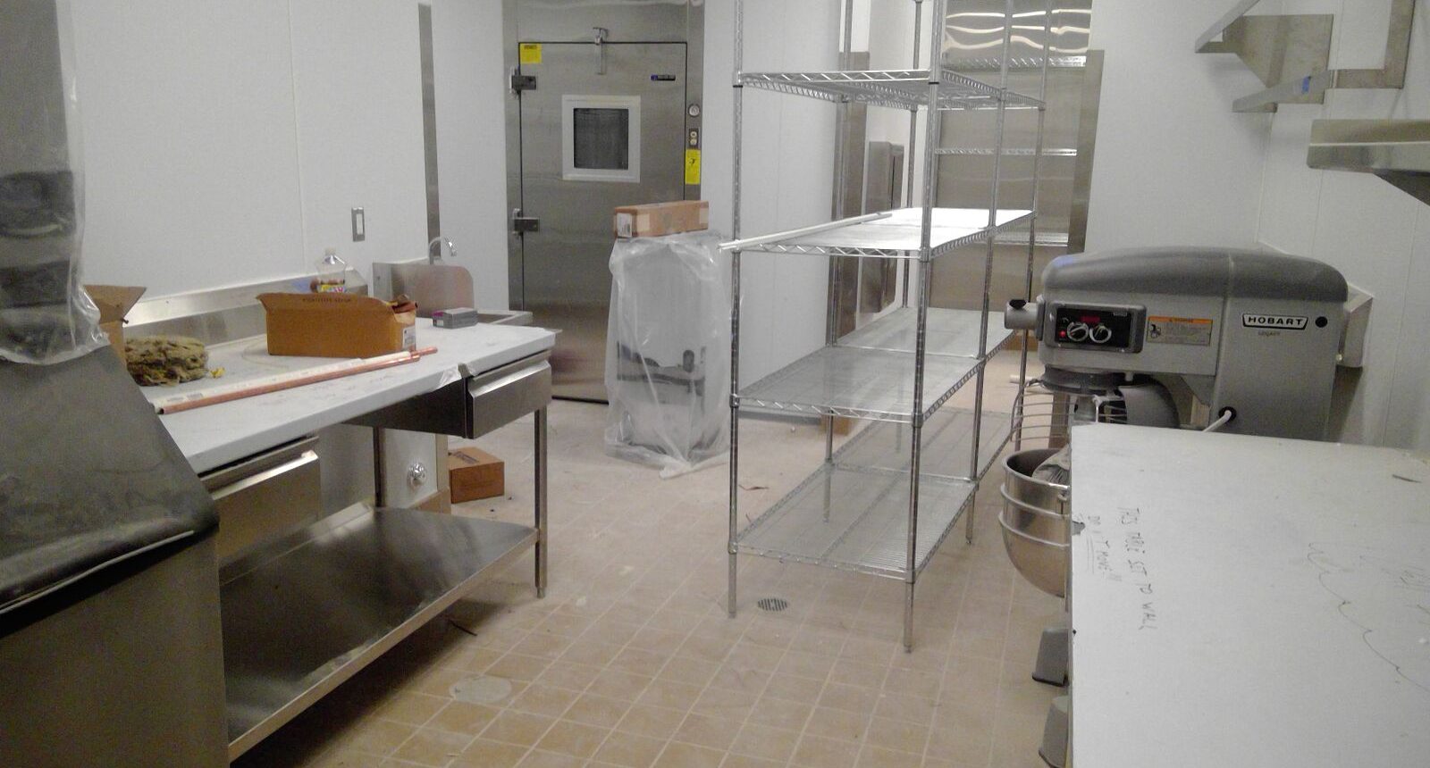 A kitchen with stainless steel counters and shelves.