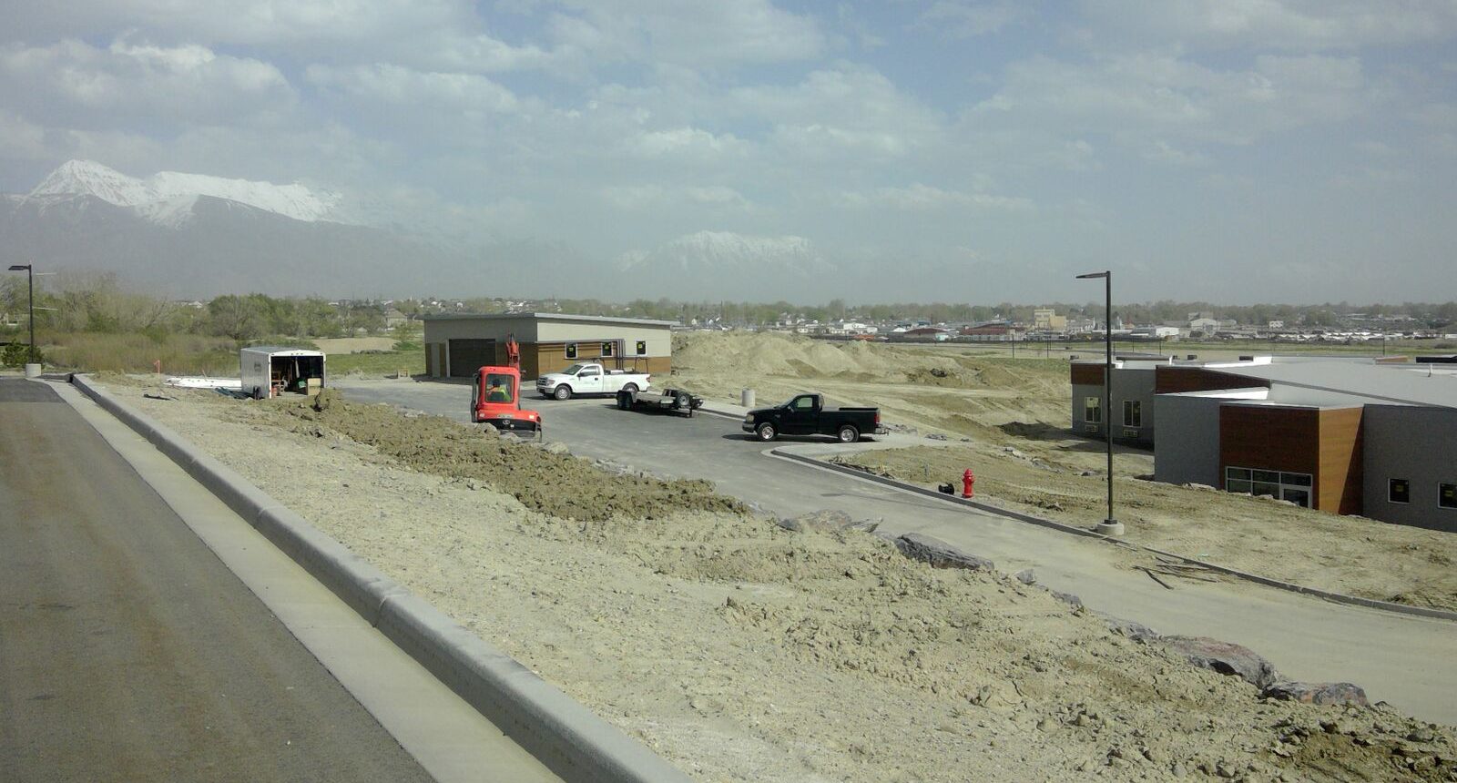 A truck is driving down the road near some buildings.