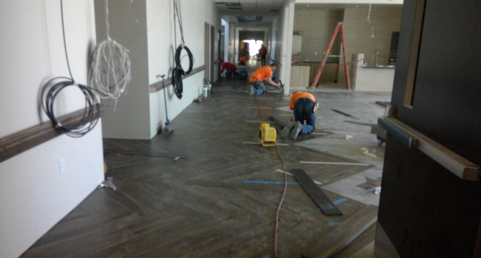 A man working on the floor of an apartment.