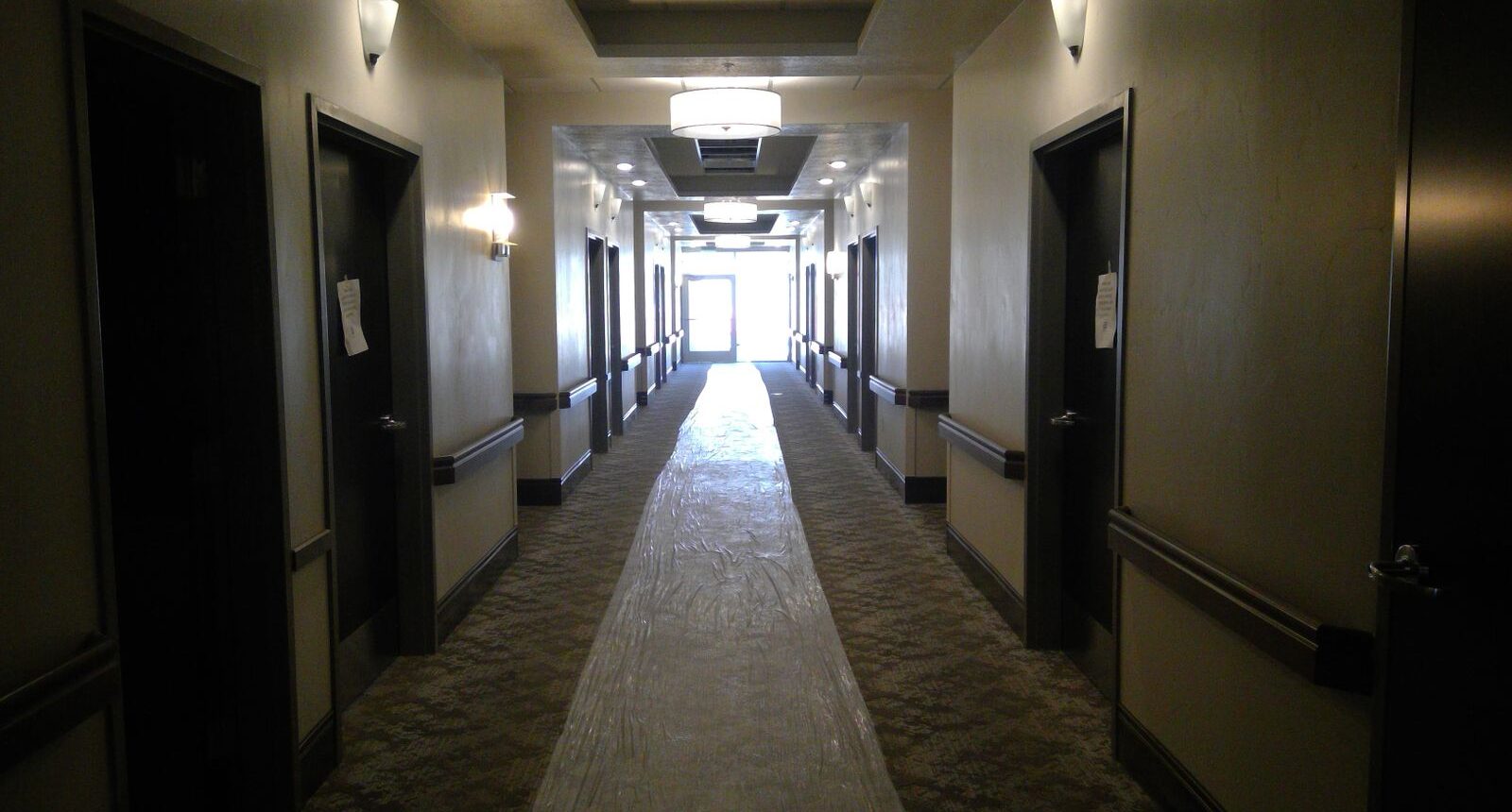 A long hallway with many doors and lights