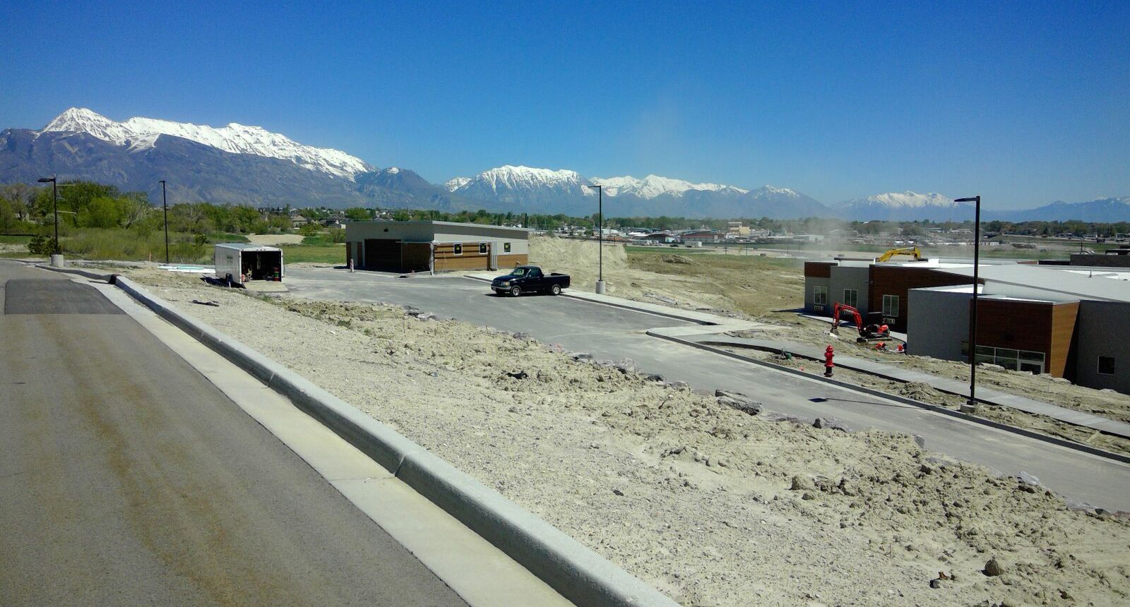 A truck is driving down the road near some mountains.