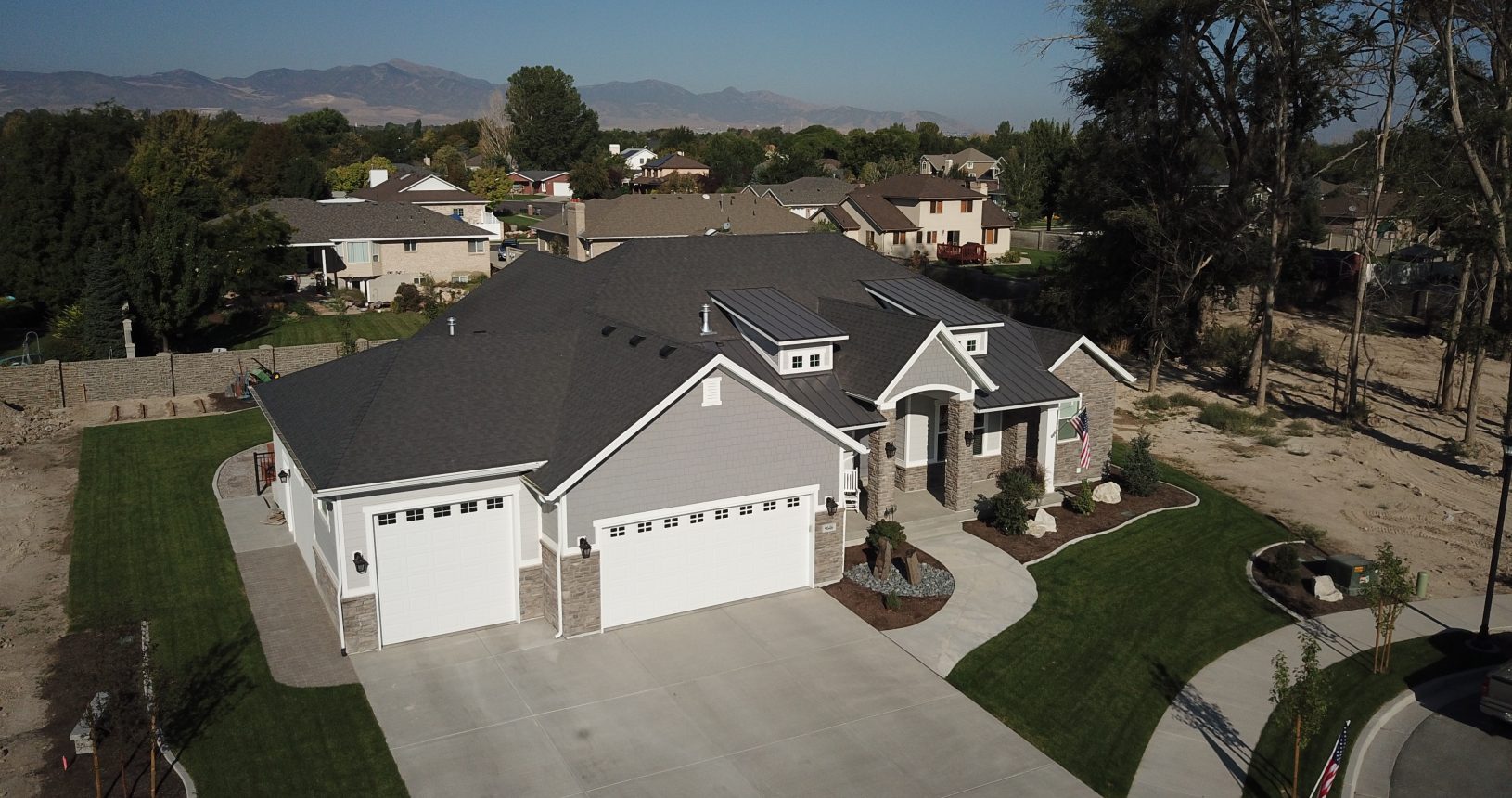 A large house with two garage doors and a driveway.